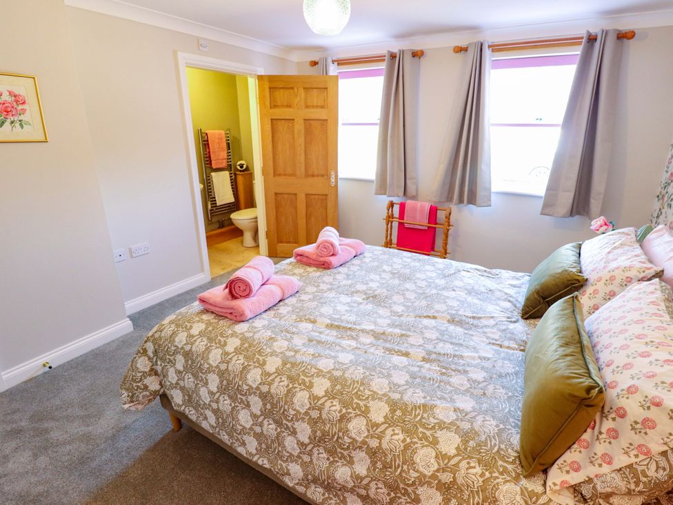 A bedroom with a bed and towels at Rowan Cottage in Boston
