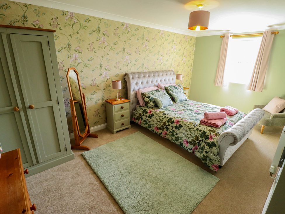 A bedroom with a bed and wardrobe at Rowan Cottage in Boston