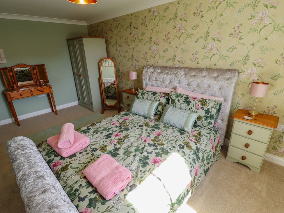 A bedroom with a bed and dressing table at Rowan Cottage in Boston