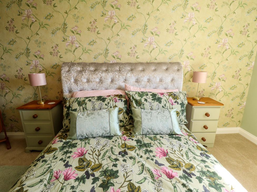 A bedroom with a bed and bedside tables at Rowan Cottage in Boston
