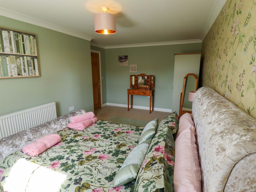 A bedroom with a bed and dressing table at Rowan Cottage in Boston