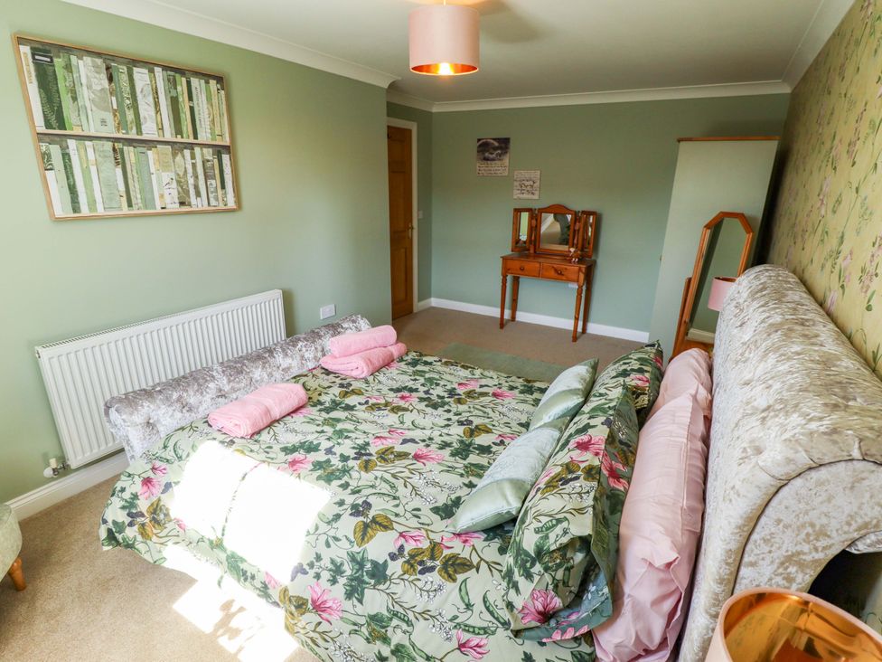 A bedroom with a bed and dressing table at Rowan Cottage in Boston