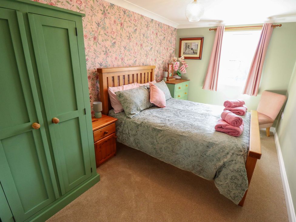 A bedroom with a bed and wardrobe at Rowan Cottage in Boston