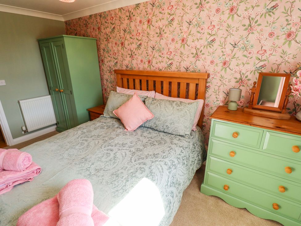 A bedroom with a bed and wardrobe at Rowan Cottage in Boston