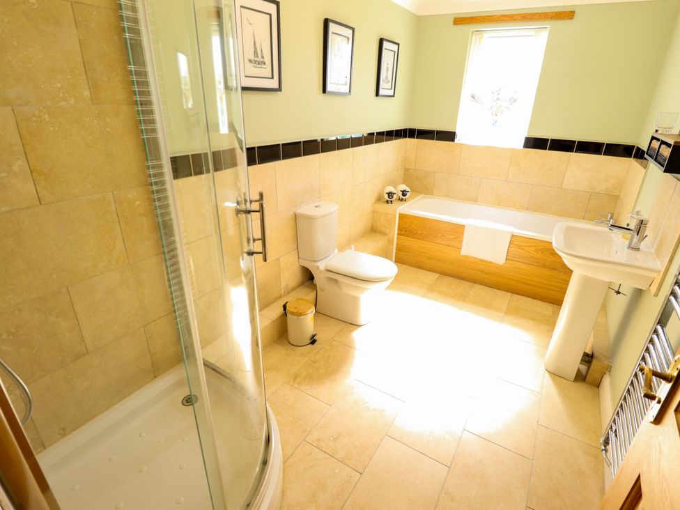 A bathroom with a shower, toilet, bathtub, and sink at Rowan Cottage in Boston