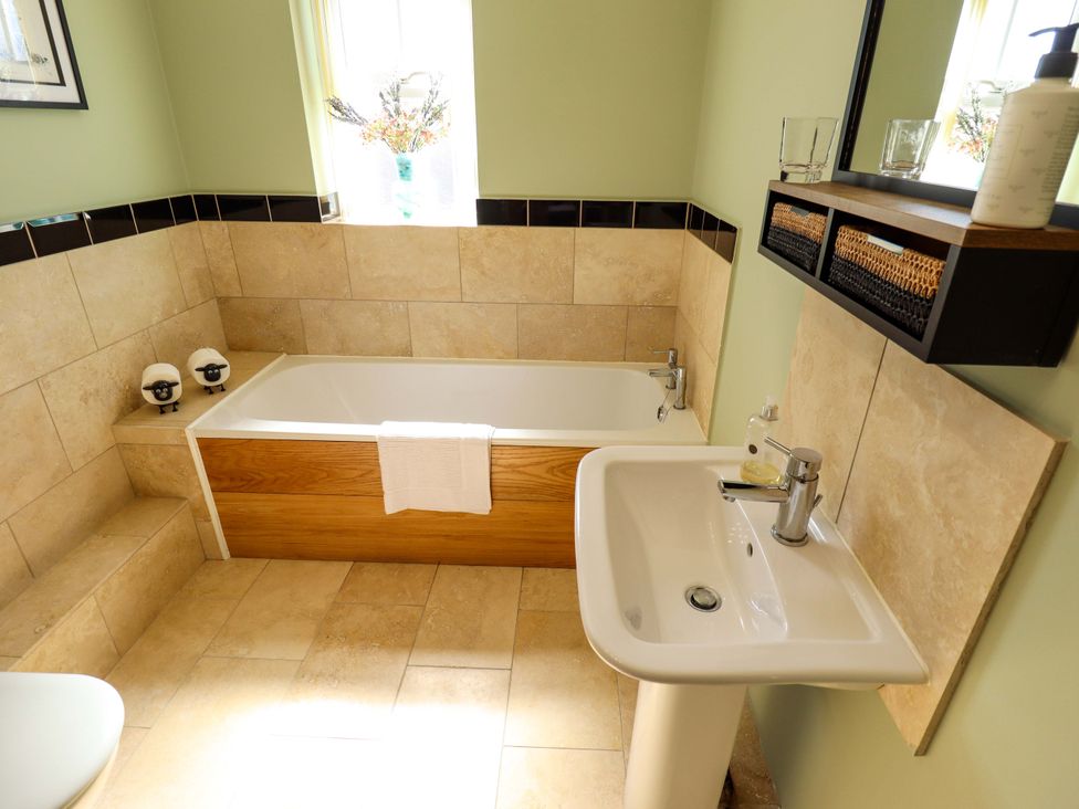 A bathroom with a bathtub and sink at Rowan Cottage in Boston