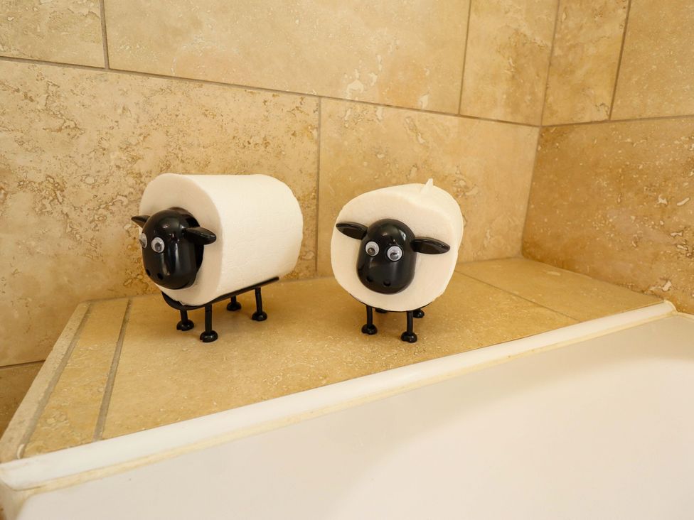 A decorative item with sheep figurines holding toilet paper at Rowan Cottage in Boston