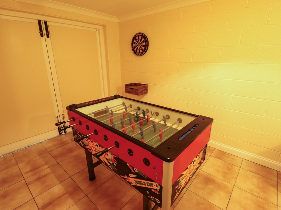 A game room with a foosball table and dartboard at Rowan Cottage in Boston