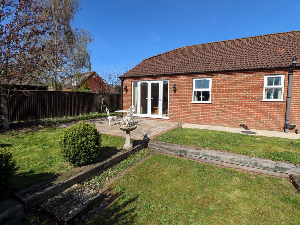 A garden with a patio and furniture at Rowan Cottage in Boston
