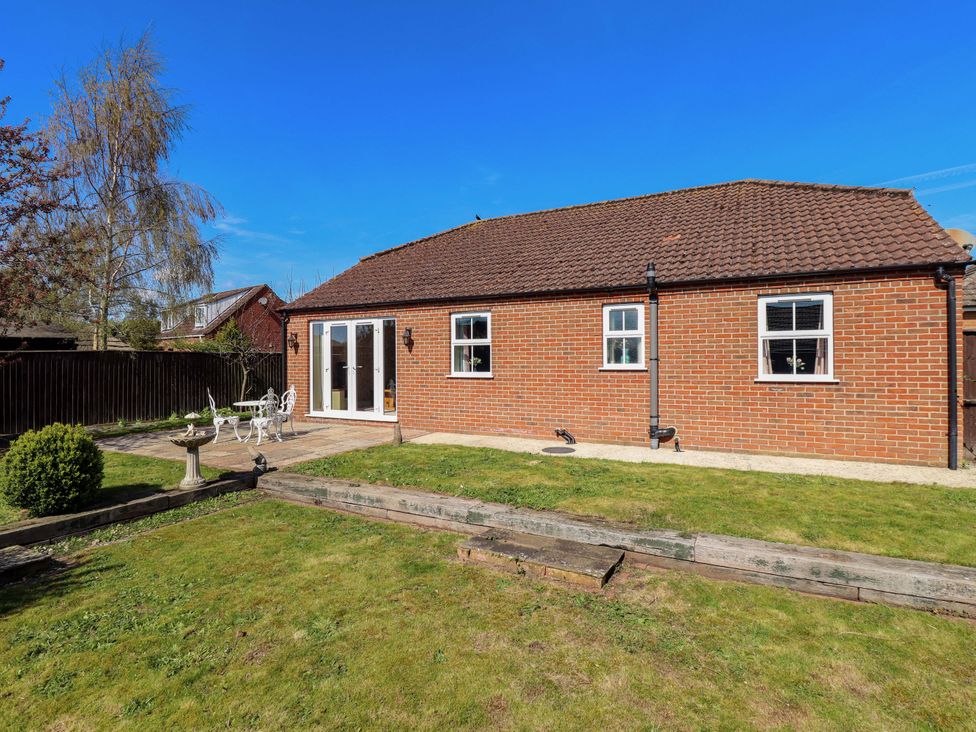 A garden with a house and chairs at Rowan Cottage in Boston
