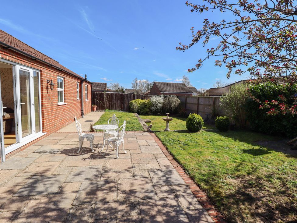A garden with a table and chairs at Rowan Cottage in Boston