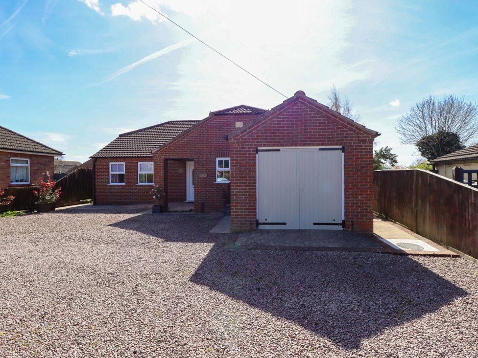 A house with a garage and driveway at Rowan Cottage in Boston