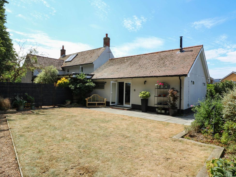 A garden with a house and bench at The Annexe @ Shotley Cottage Shotley Gate