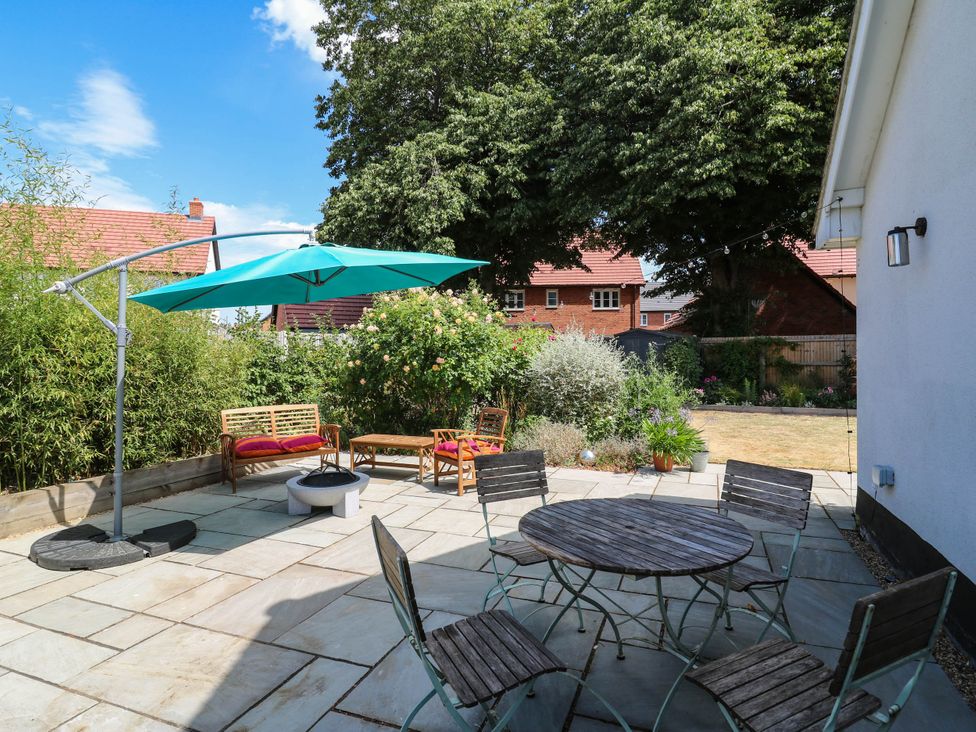 A garden with a table and chairs and an umbrella at The Annexe @ Shotley Cottage Shotley Gate