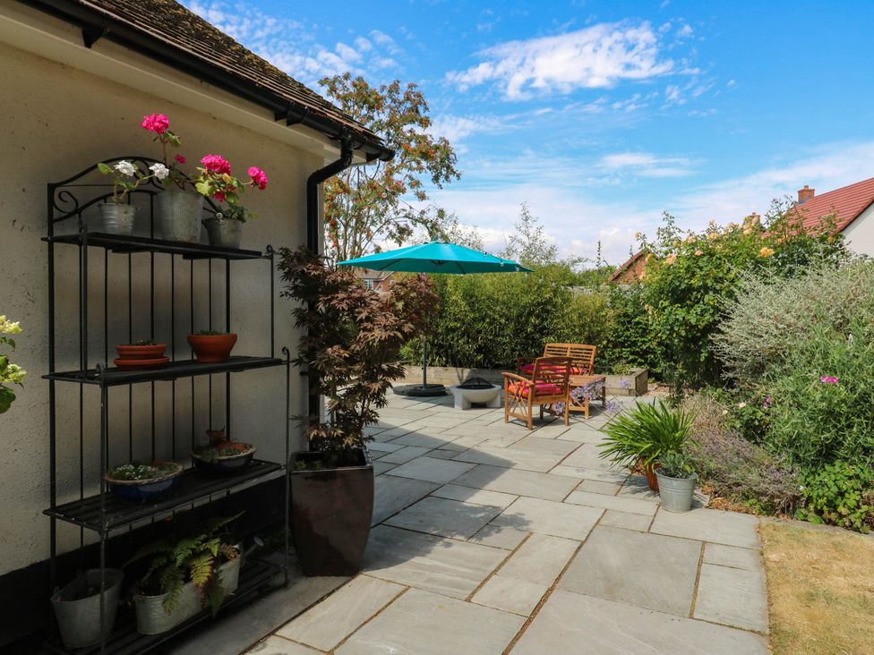A garden with a shelving unit and seating area at The Annexe @ Shotley Cottage in Shotley Gate