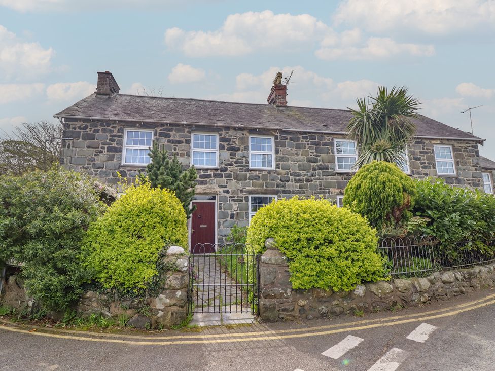A house with a stone wall and garden at Glanrafon 