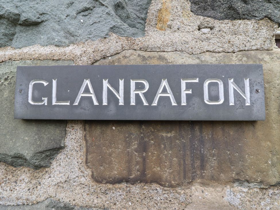 A sign that reads GLANRAFON mounted on a stone wall
