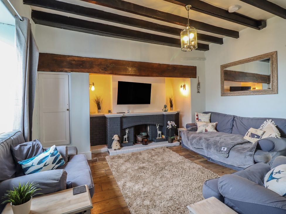 A living room with a television and sofa at Glanrafon