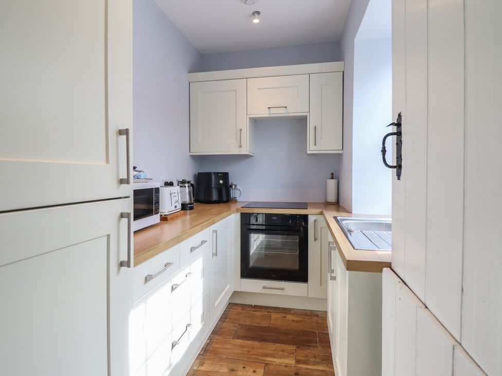A kitchen with a microwave, kettle, and oven at Glanrafon