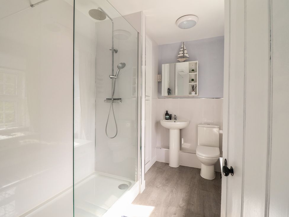 A bathroom with a shower, sink, and toilet at Glanrafon