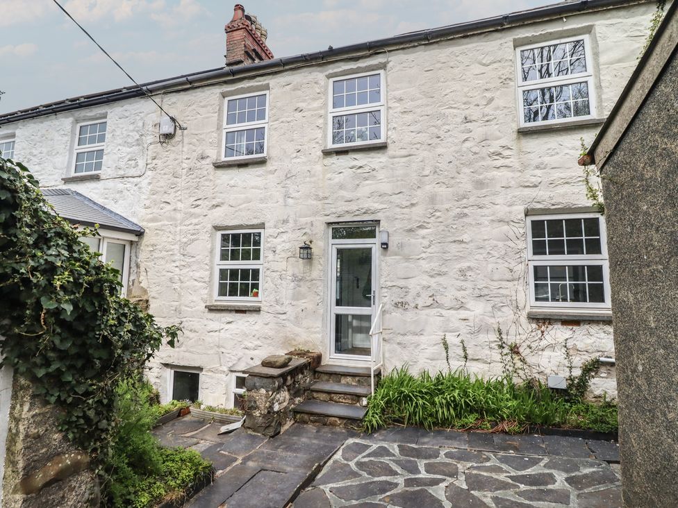 A stone building with windows and a door at Glanrafon