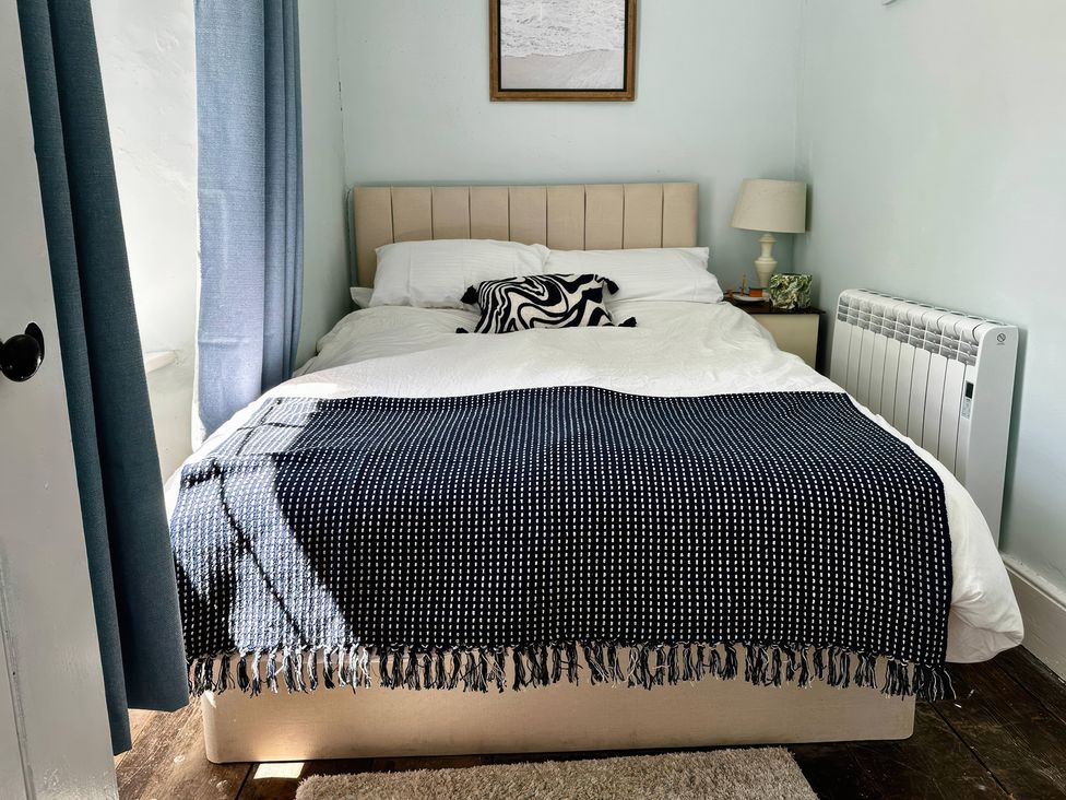 A bedroom with a bed and lamp at Glanrafon in Llwyngwril