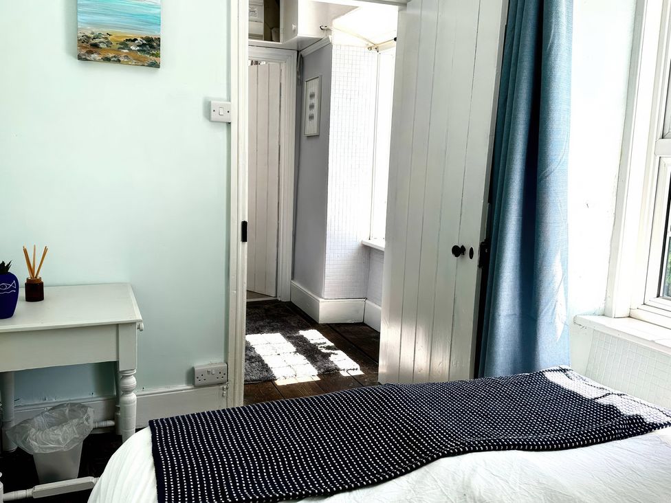 A bedroom with a door and window at Glanrafon in Llwyngwril