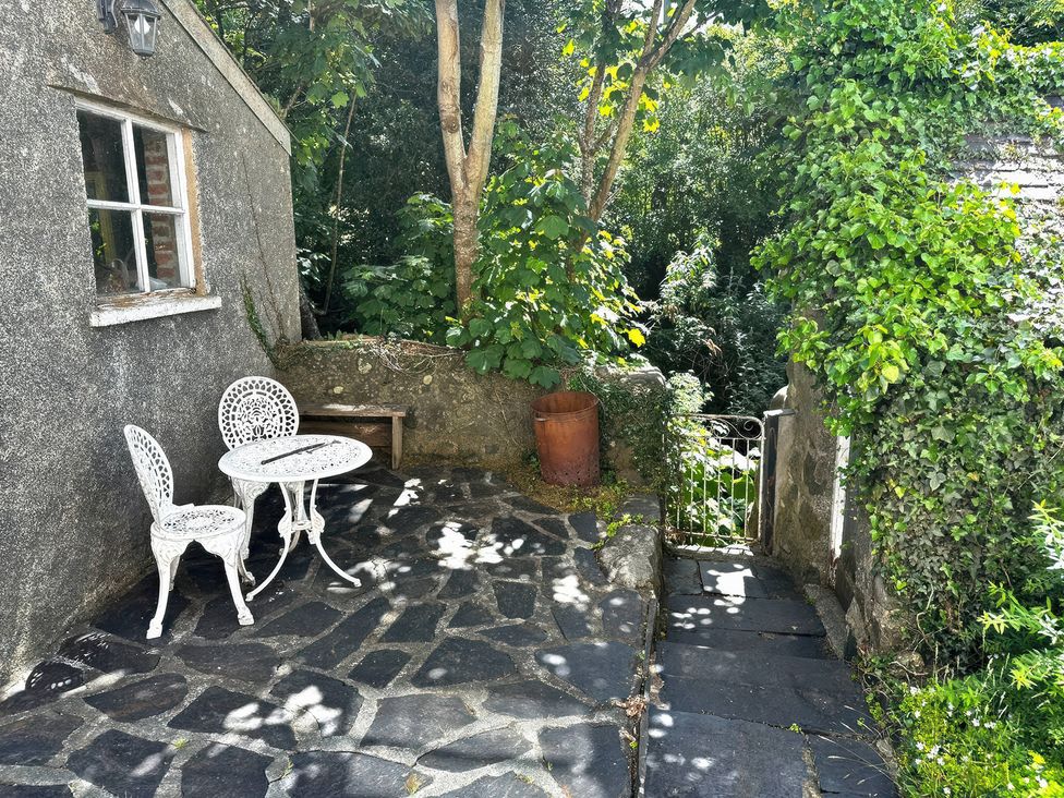 A garden with a table and chairs at Glanrafon in Llwyngwril