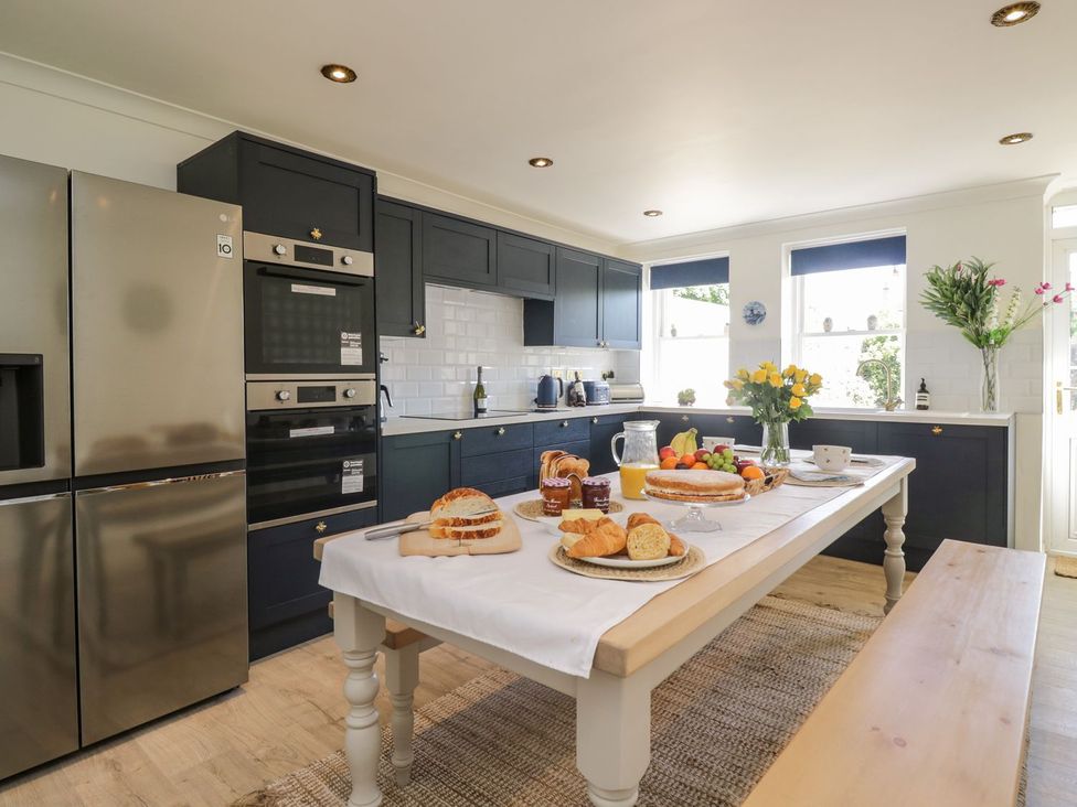 A kitchen with appliances and a table set for breakfast at Admirals home