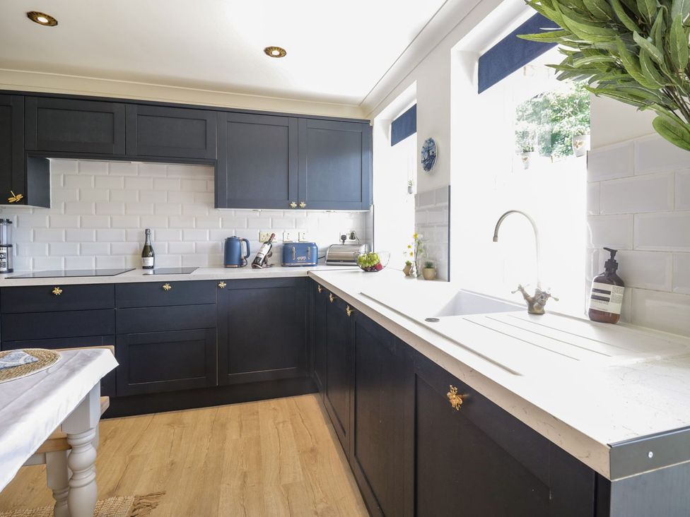 A kitchen with dark cabinets and a white sink at Admirals home