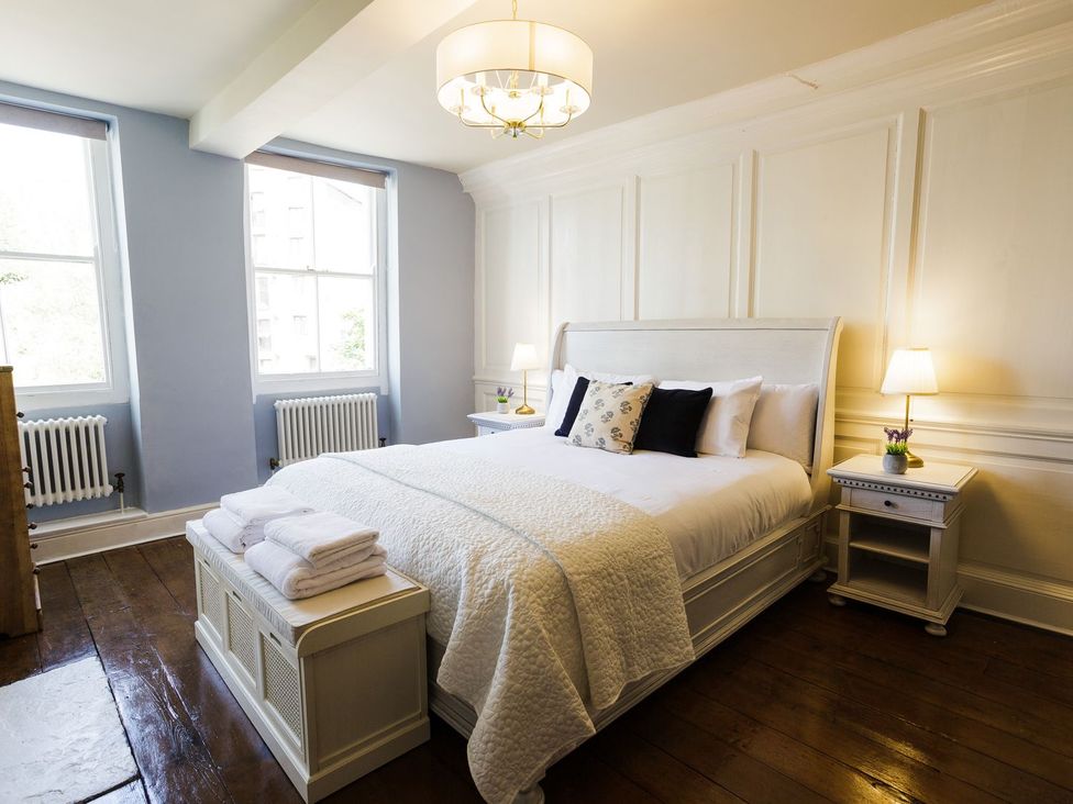 A bedroom with a bed and bedside tables at Admirals home 