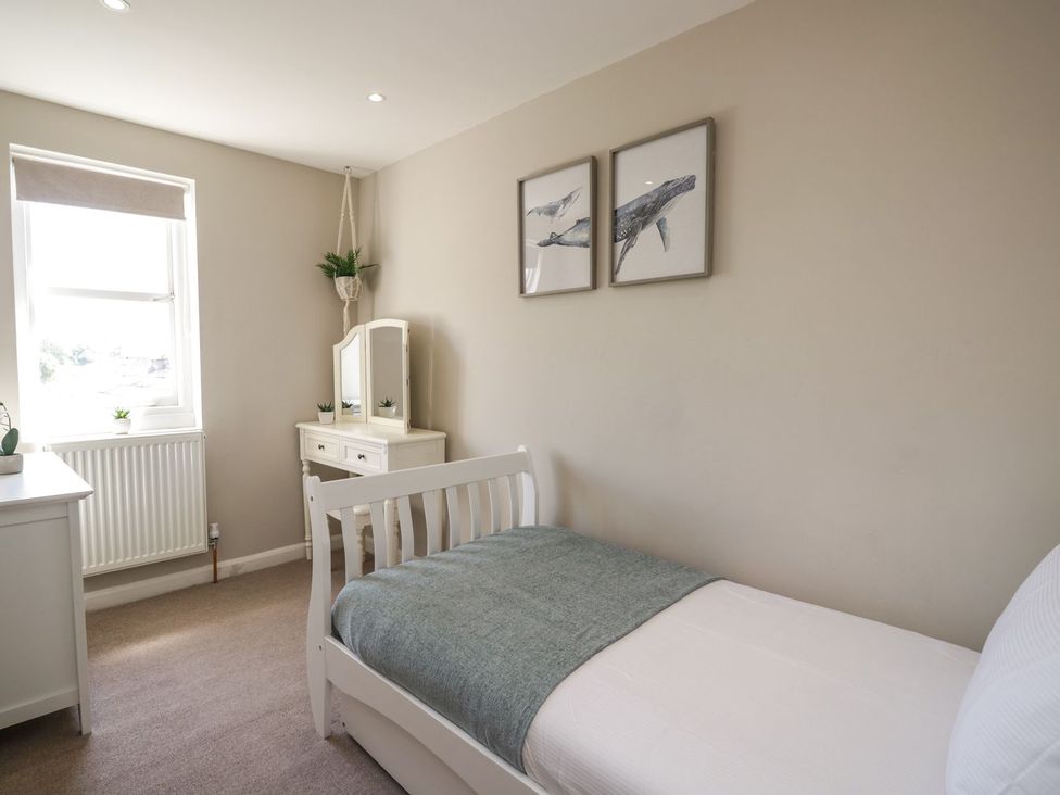 A bedroom with a bed and dresser at Admirals home