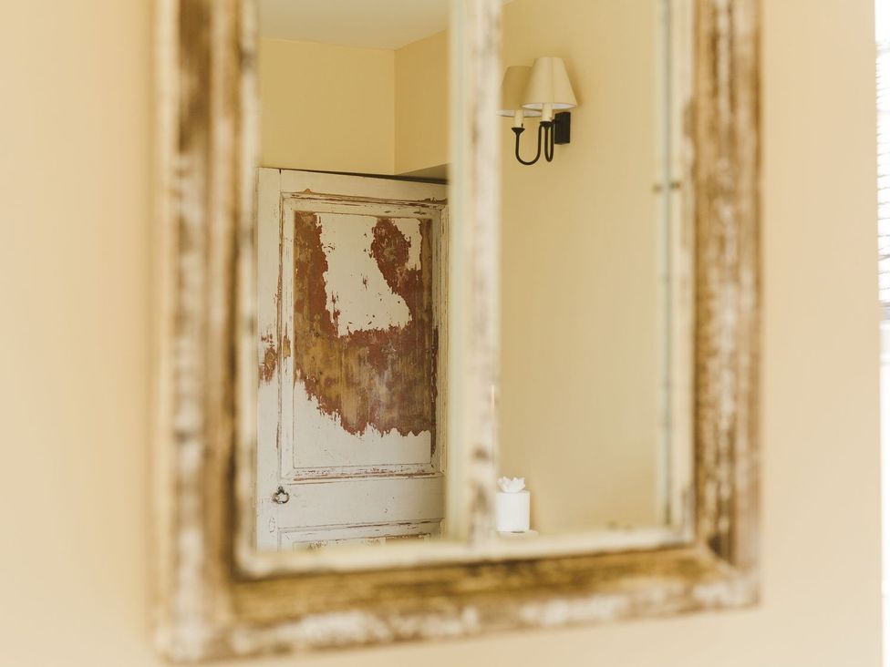 A mirror reflecting a door and a light fixture at Admirals home
