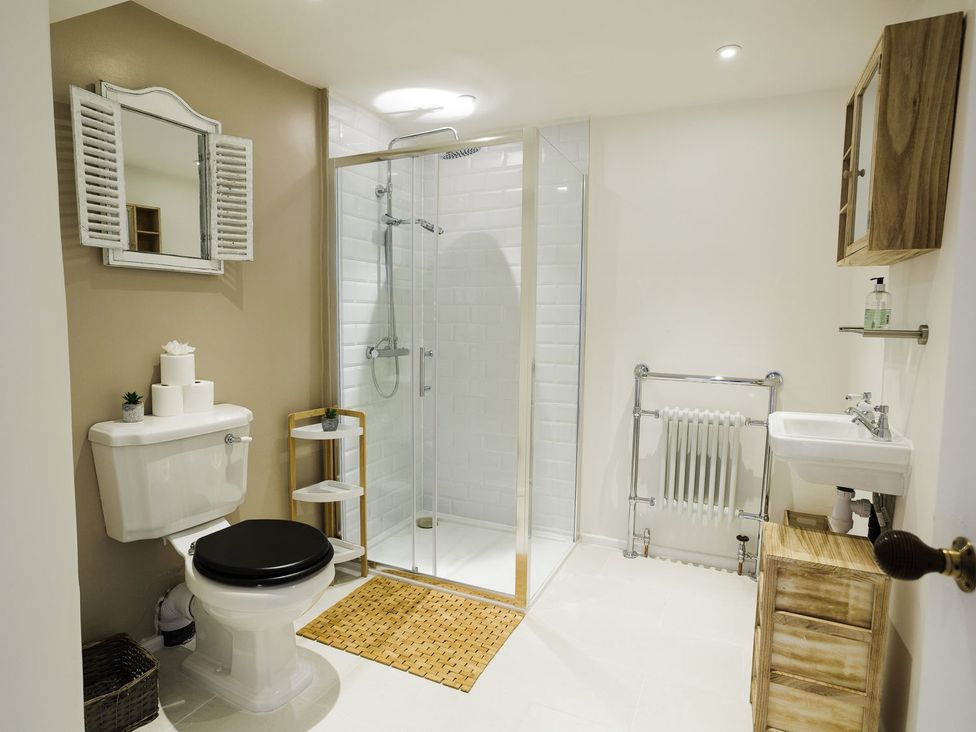 A bathroom with a shower, toilet, and sink at Admirals home