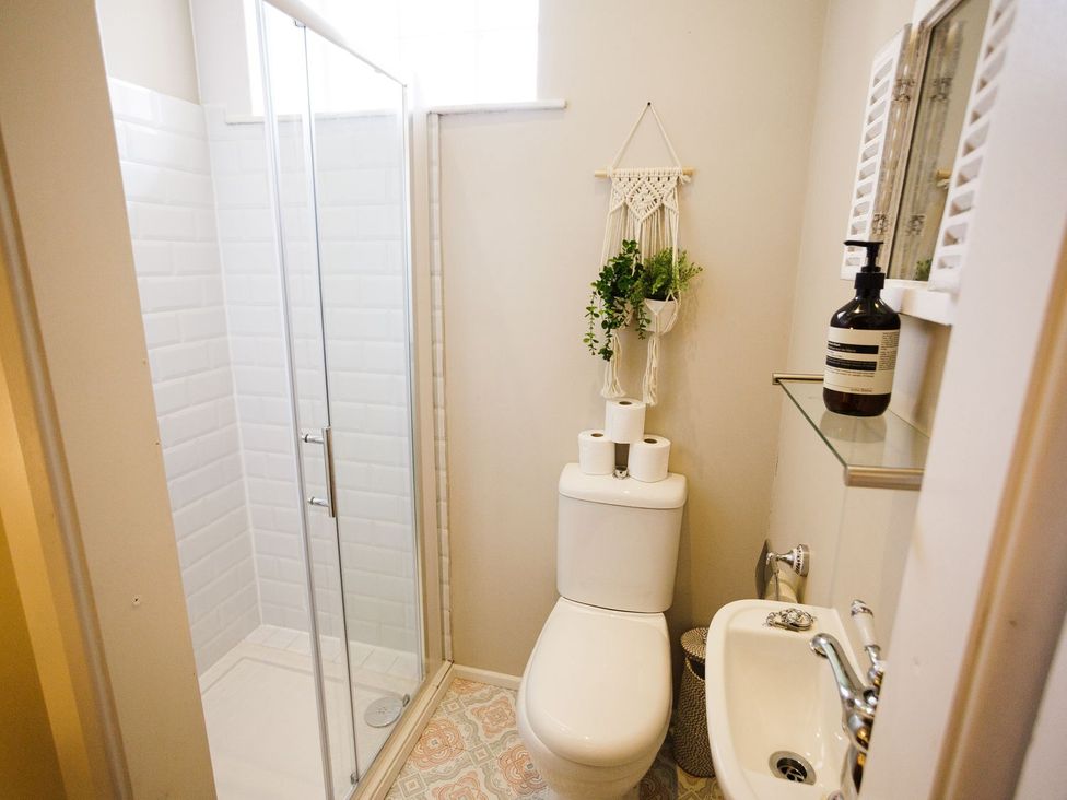 A bathroom with a shower, toilet, and sink at Admirals home