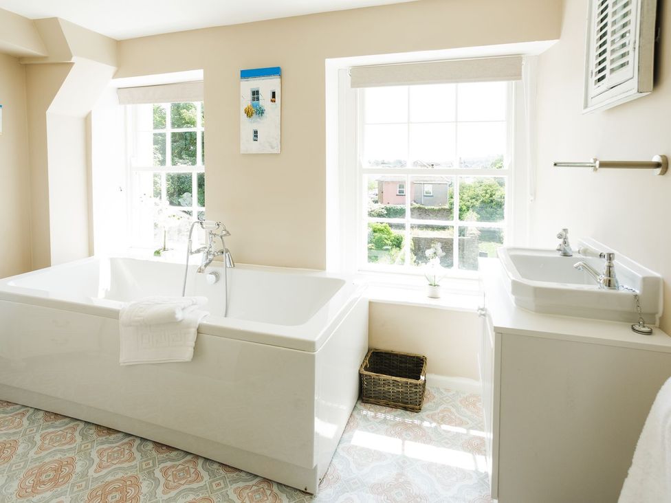 A bathroom with a bathtub and sink at Admirals home