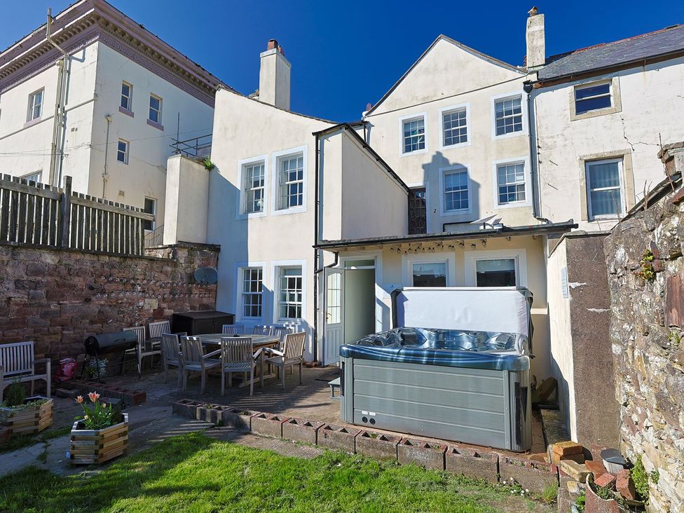 A garden with a hot tub and dining table at Admirals home