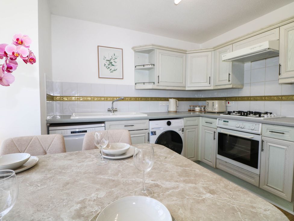 A kitchen with appliances and dining table at 4 Atlantic Close Southampton