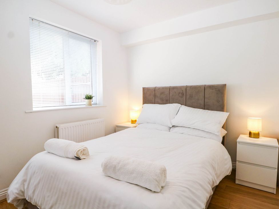 A bedroom with a bed and nightstands at 4 Atlantic Close Southampton