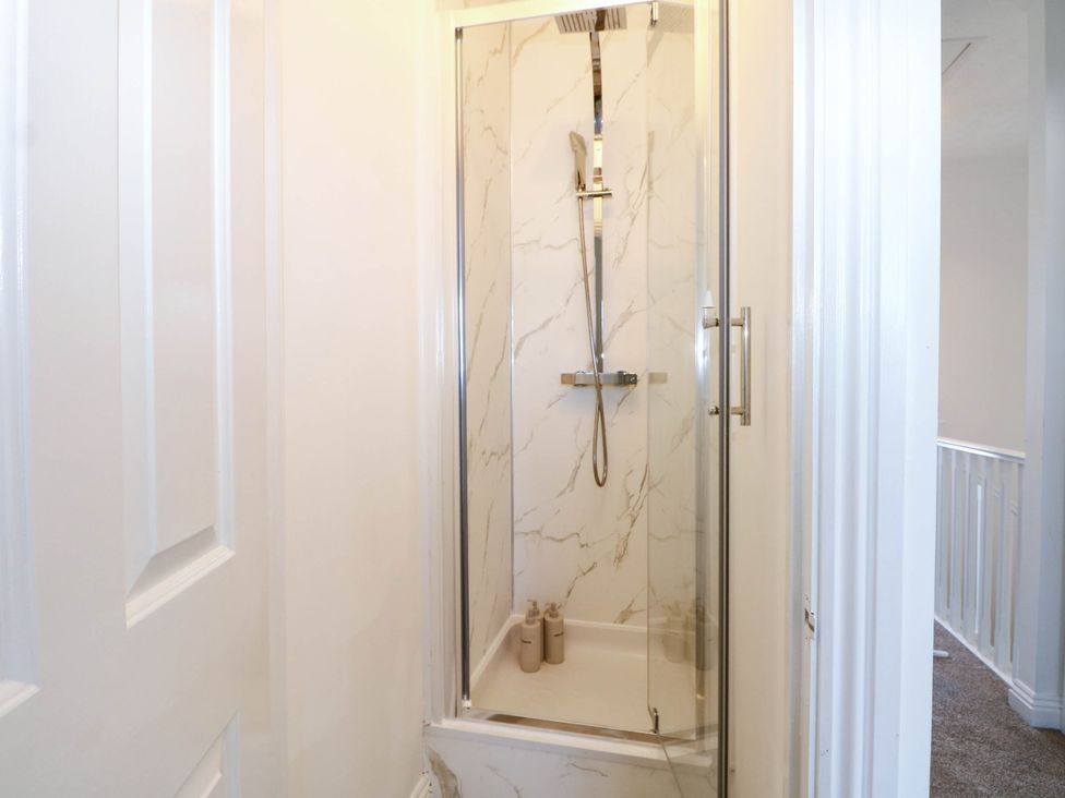 A shower with glass doors and wall panels at 4 Atlantic Close Southampton