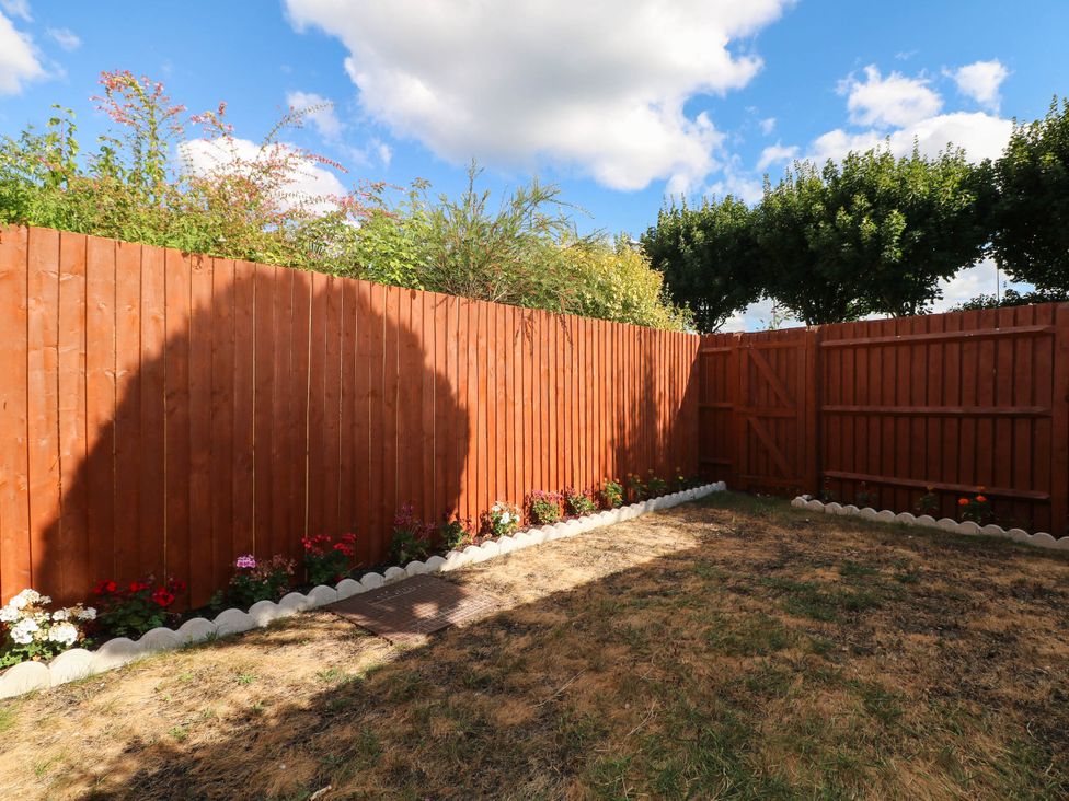 A garden with a wooden fence and flower beds at 4 Atlantic Close Southampton