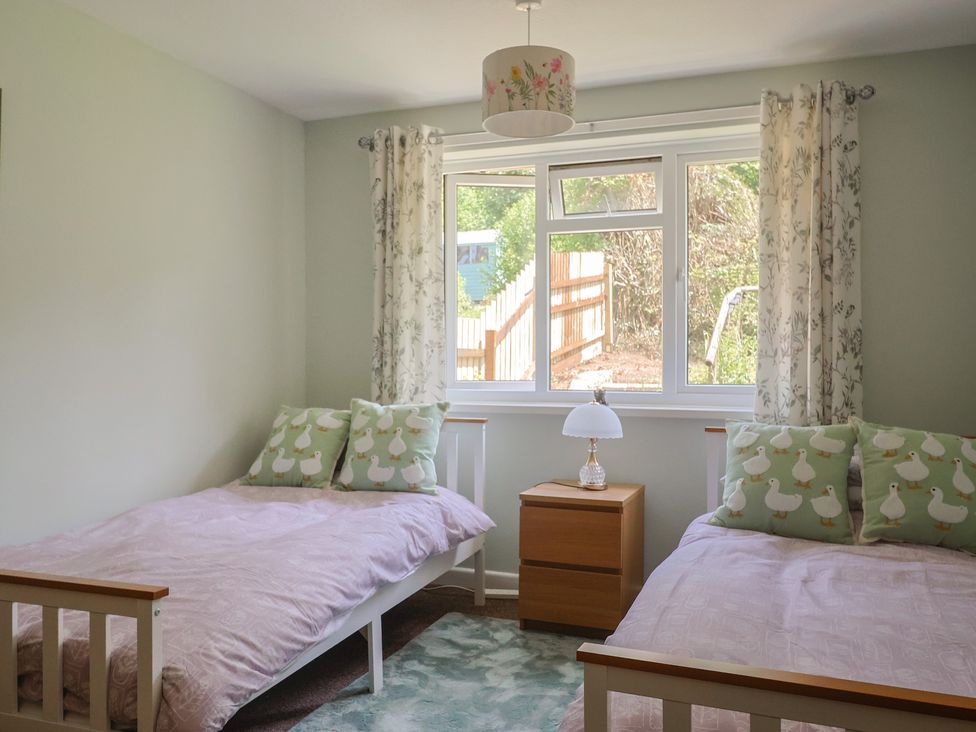 A bedroom with two beds and a window at Tane in Winterborne Stickland