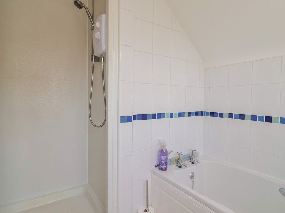 A bathroom with a shower and bath tub at Tane in Winterborne Stickland