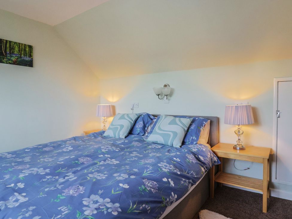 A bedroom with a bed and bedside tables at Tane in Winterborne Stickland