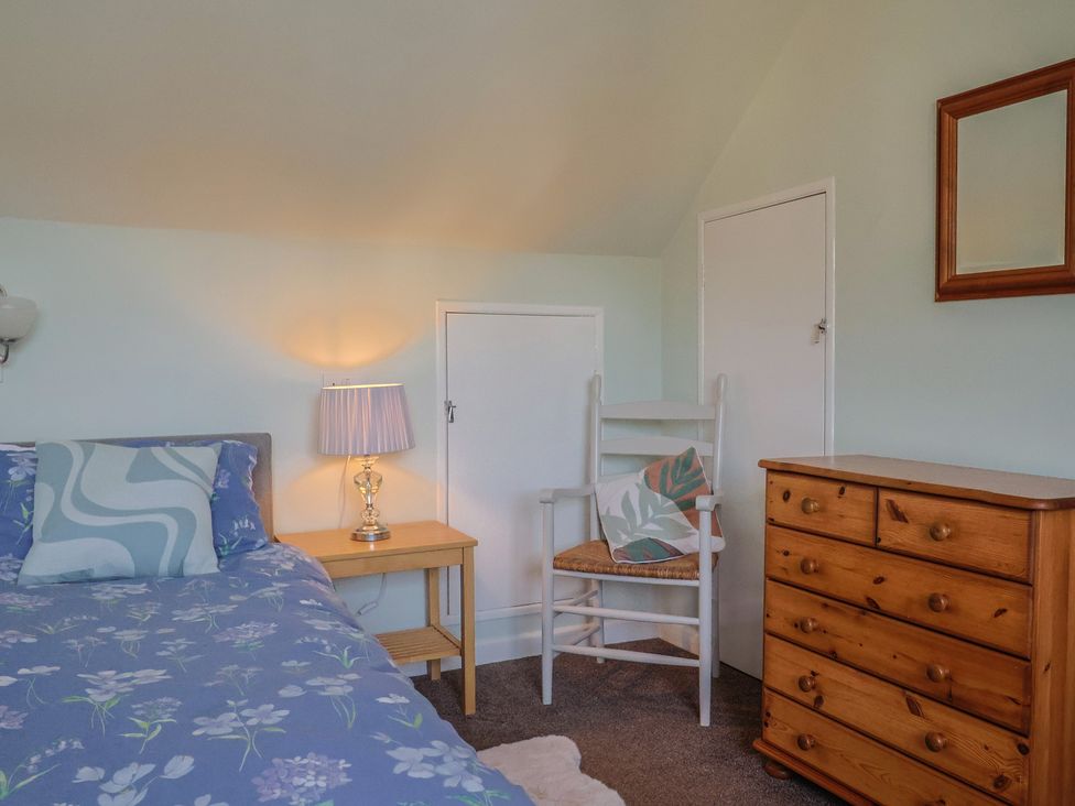 A bedroom with a bed and dresser at Tane in Winterborne Stickland