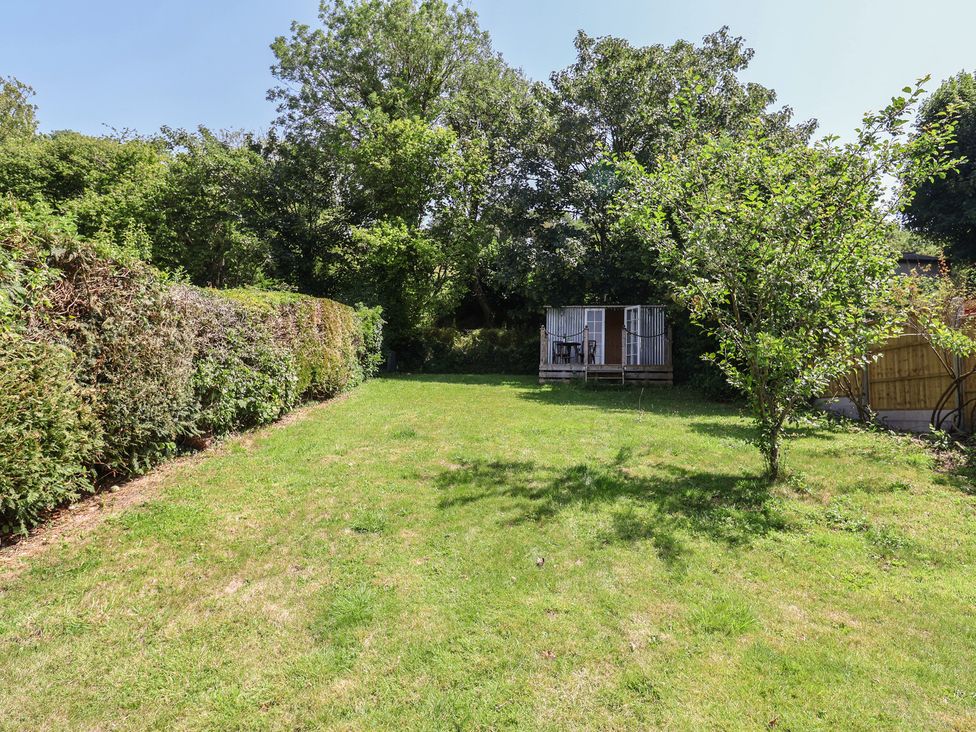 A garden with grass and a shed at Tane in Winterborne Stickland