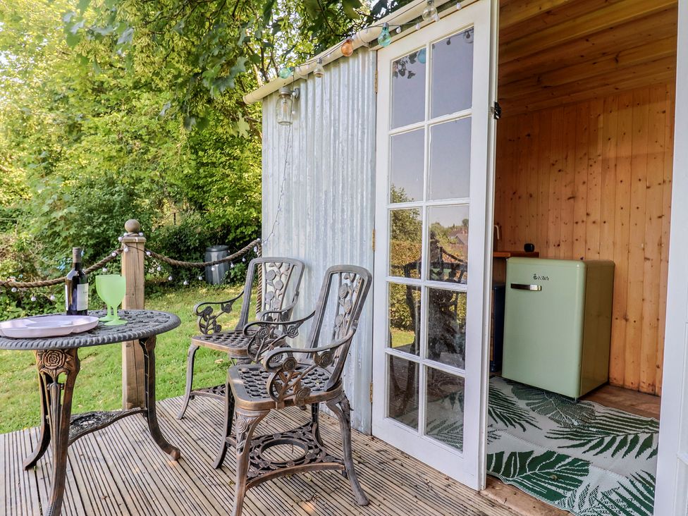 An outdoor seating area with a table and chairs at Tane in Winterborne Stickland