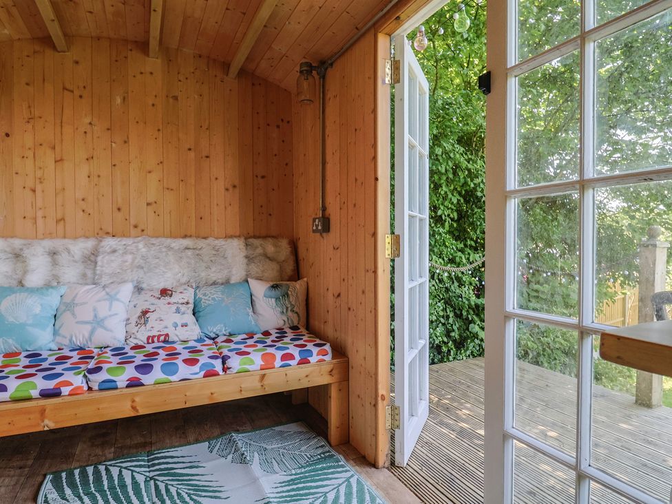 A snug with a sofa and cushions at Tane in Winterborne Stickland