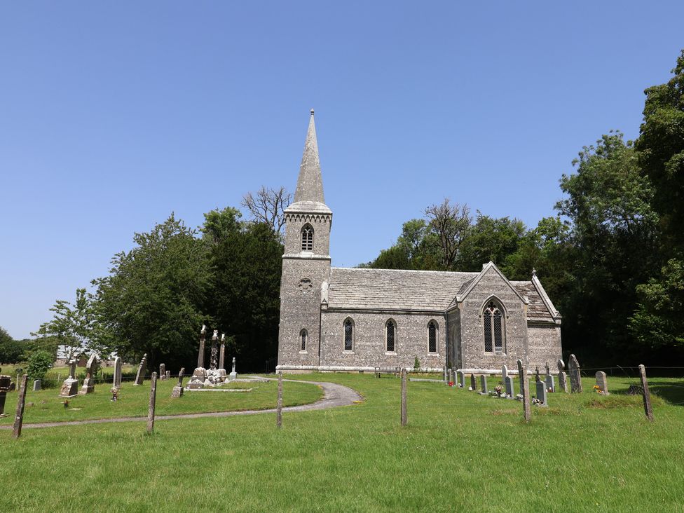 A church surrounded by graves and trees at Tane in Winterborne Stickland