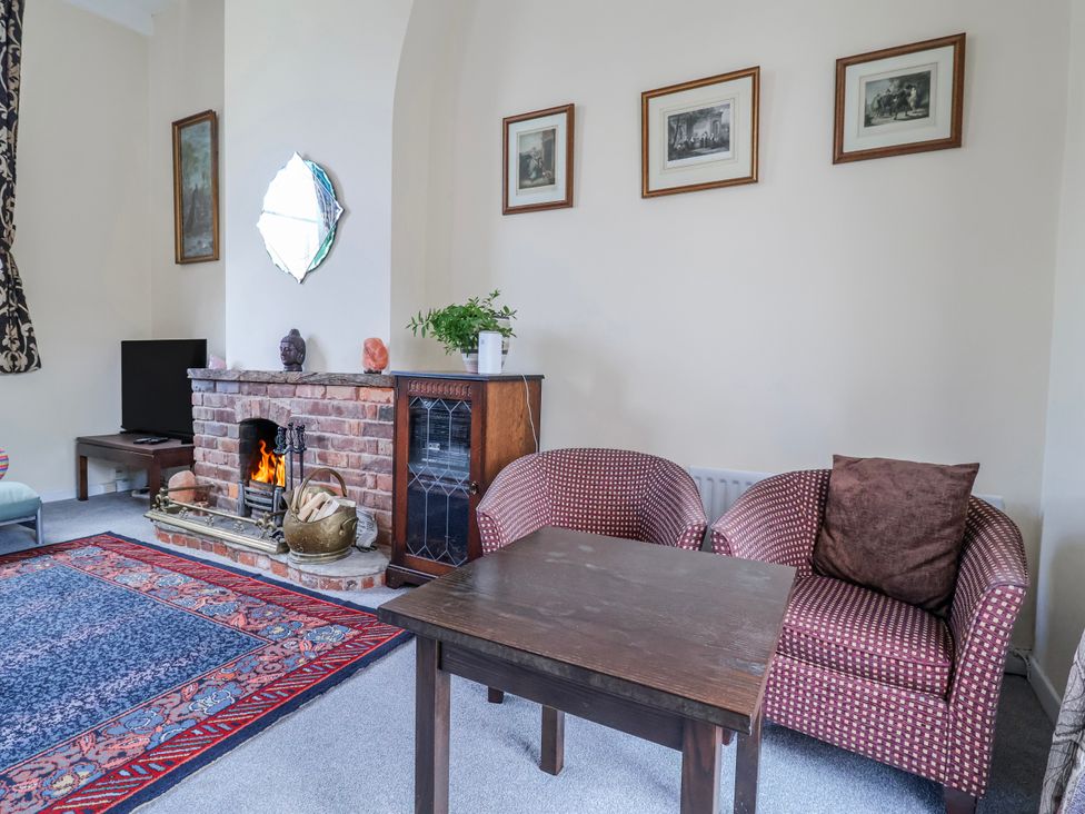 A living room with a fireplace and armchairs in a top floor apartment